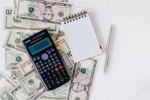 Calculate, notebook, pen and money on a table